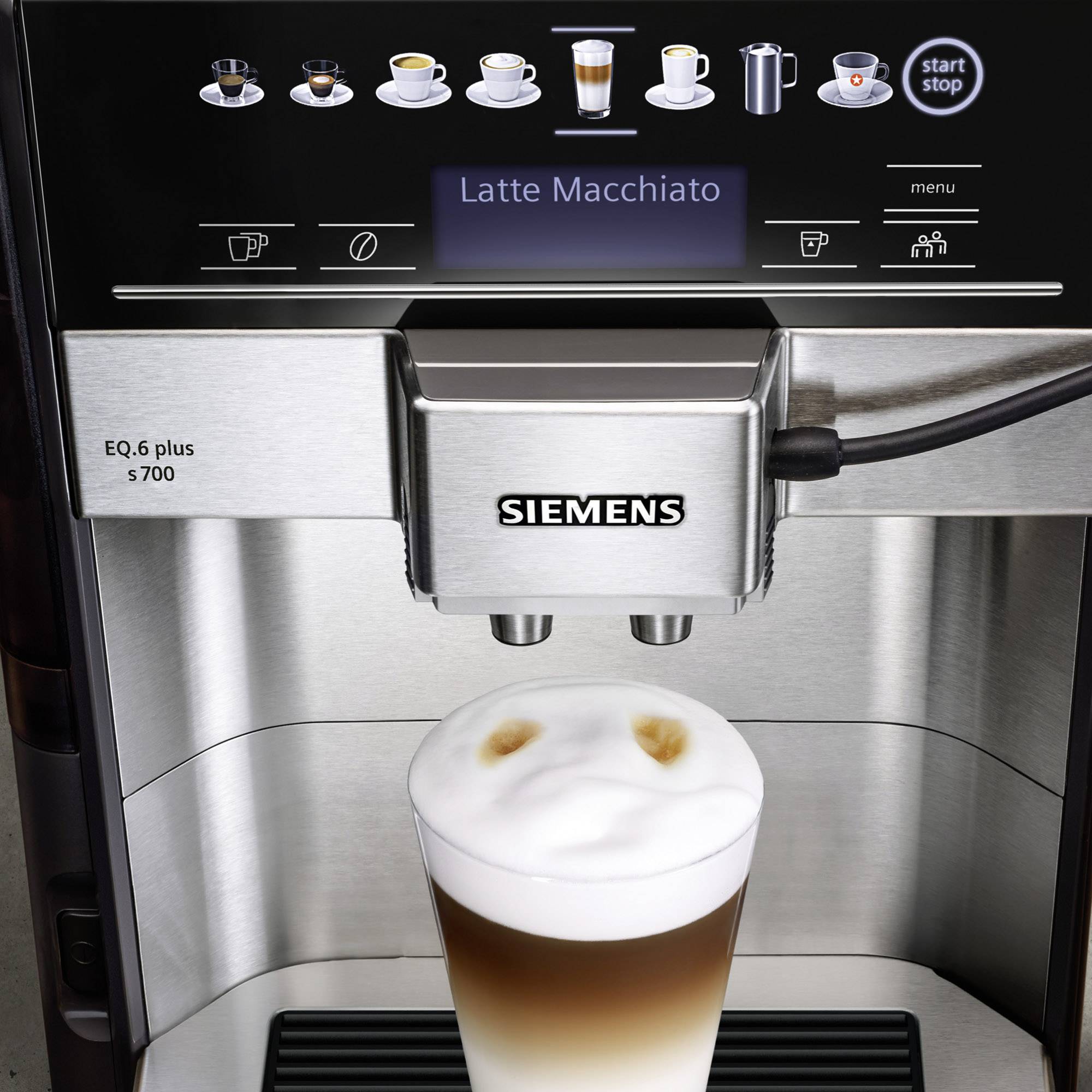 Kávový automat pripravuje latte macchiato. Na displeji hore sú viditeľné rôzne kávové symboly a ovládacie prvky.