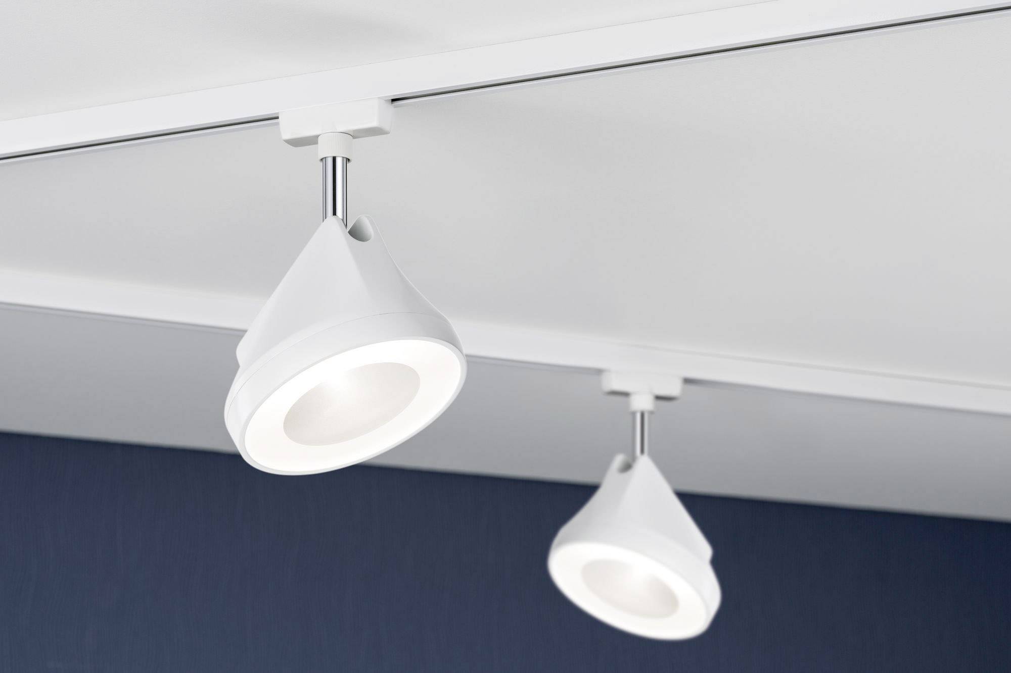 'Dva moderné, biele stropné reflektory namontované na koľajničke svietia do miestnosti.'