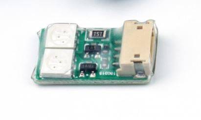 Malá zelená elektronická doska s viacerými komponentmi vrátane dvoch strieborných čipov a béžového konektora na pravej strane.
