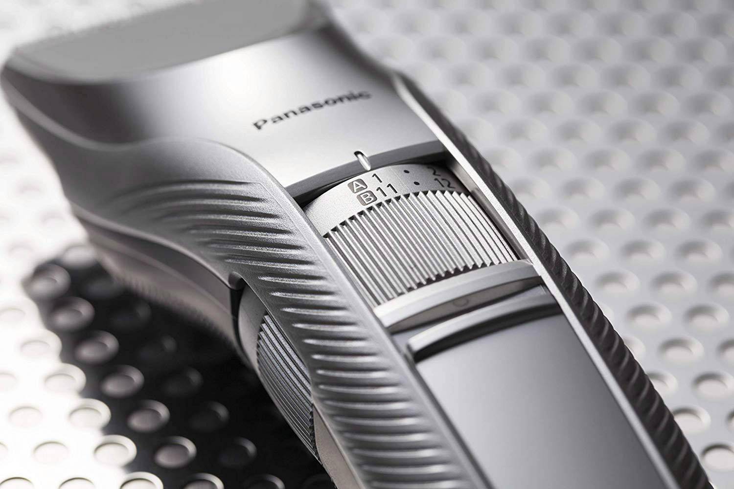 Elektrický zastrihávač vlasov s ergonomickým dizajnom a nastaviteľnou dĺžkou strihania, umiestnený na kovovom povrchu.