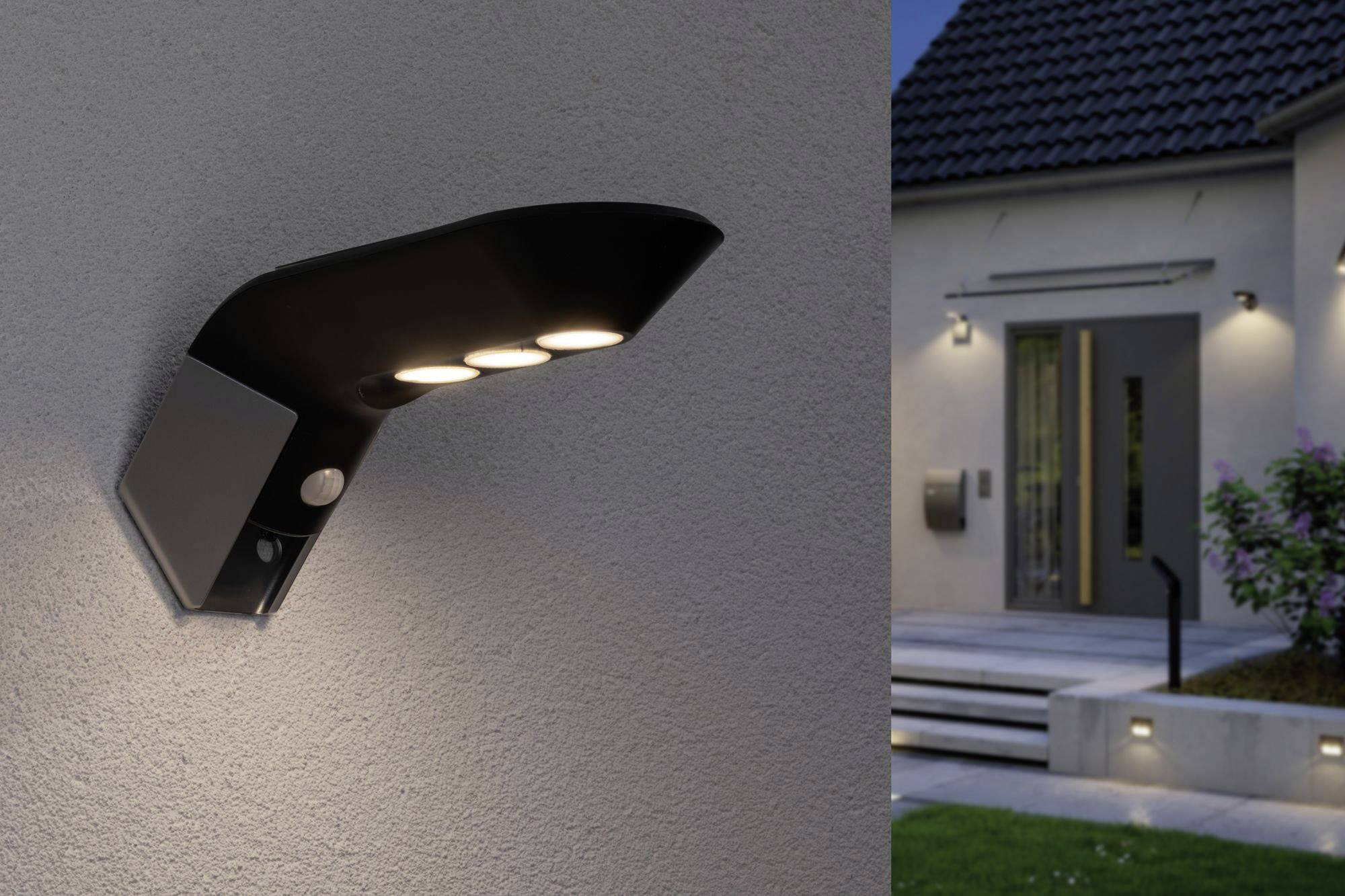 Nástenná lampa s tromi LED žiarovkami osvetľuje vonkajšiu budovu, osvětlenie vstupnej oblasti počas večera; moderná architektúra.