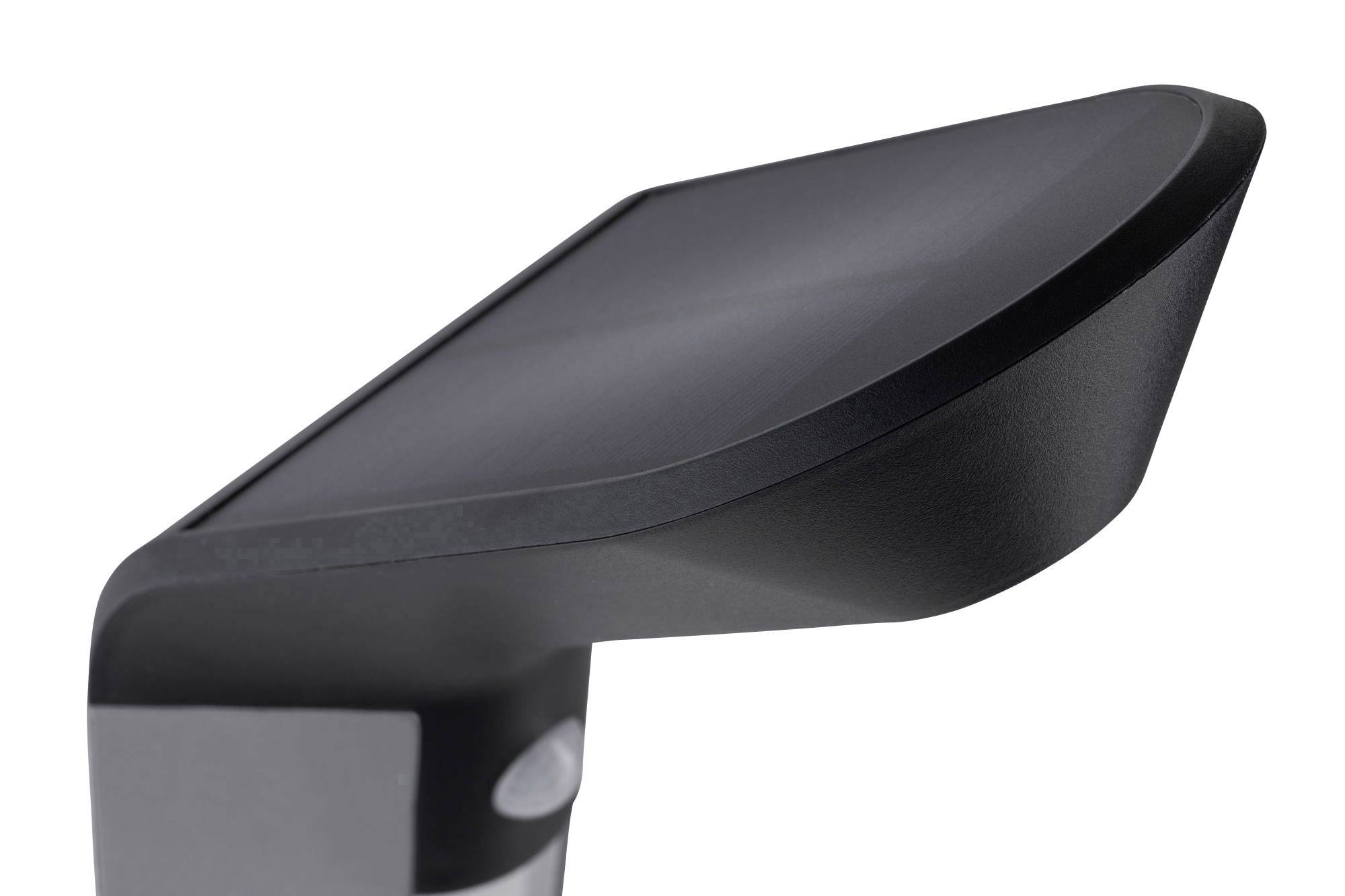 Čierne, moderné vonkajšie nástenné svietidlo s zalomeným dizajnom a plochou hornou stranou.