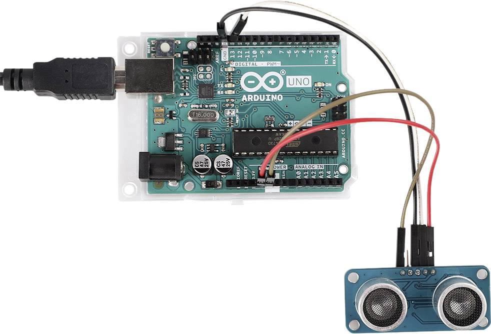 Arduino Uno doska s pripojeným ultrazvukovým senzorom. Káble spájajú senzorové piny s pinmi Arduino dosky, napájanie v ľavom hornom rohu.