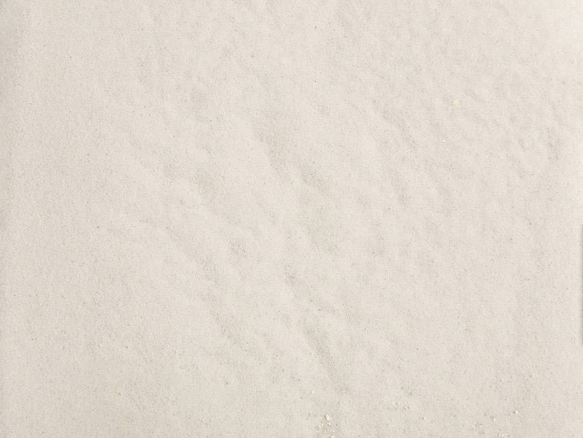 Jemný, svetlý piesok s rovnomernou textúrou.