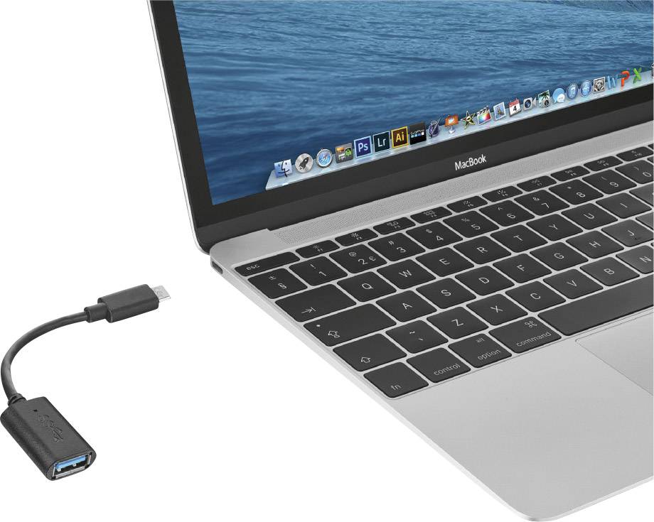 Strieborný laptop s čiernou klávesnicou. Vedľa neho leží čierny adaptér s USB a USB-C portami.
