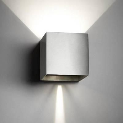 Nástenna lampa v kubickom tvare z kovu, vyžarujúca svetlo smerom nahor a nadol; moderný, minimalistický dizajn.