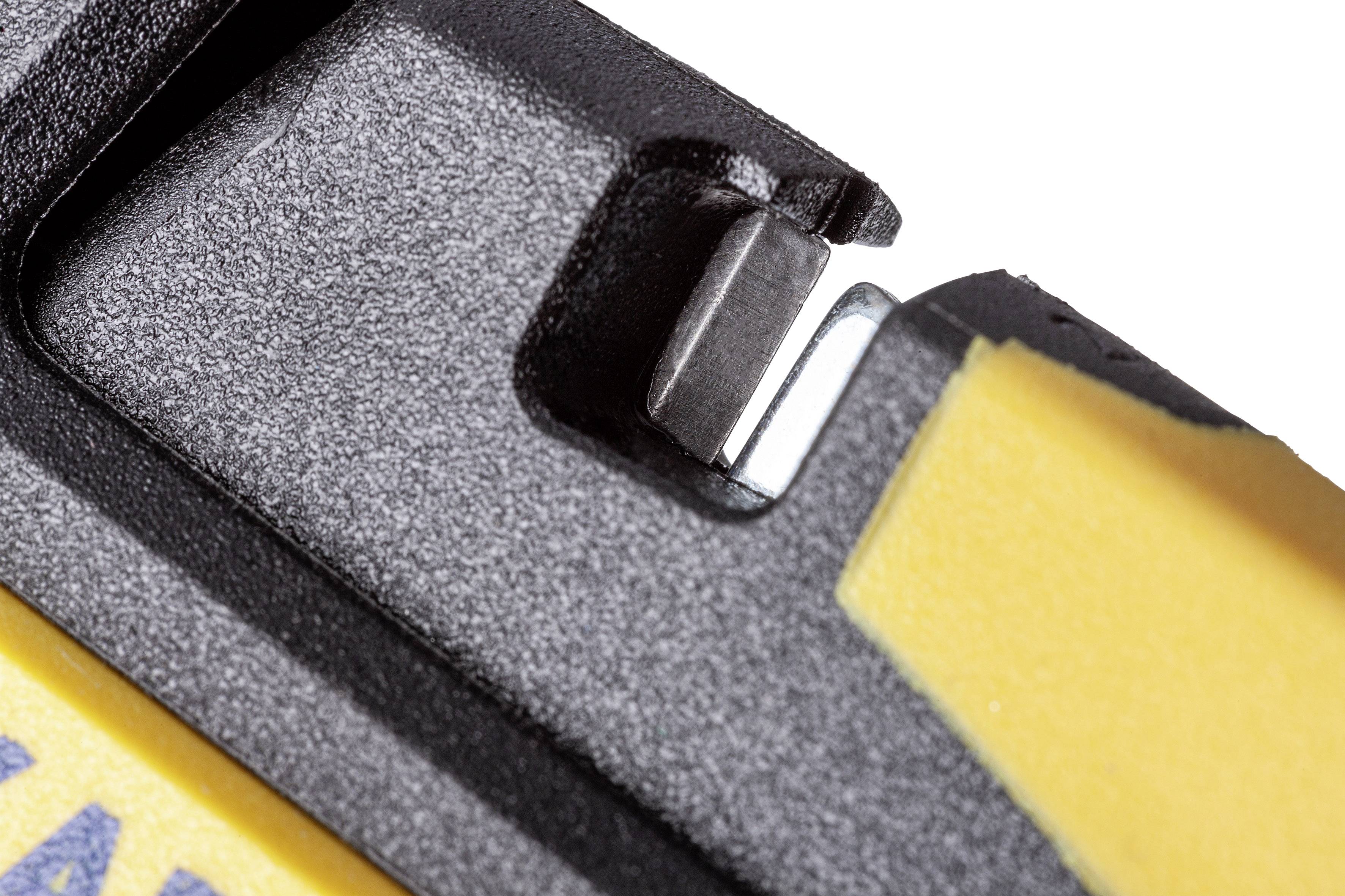 Žltý a čierny nástroj s ostrím kovovej čepele určený na rezanie materiálov, detail ostria.