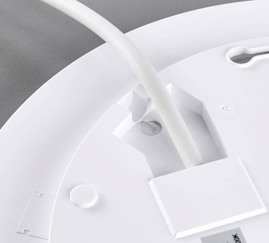 Montáž elektronického zariadenia na strope, detailný záber: káble vedené cez otvor, viditeľné body na uchytenie skrutiek, na sivom povrchu.