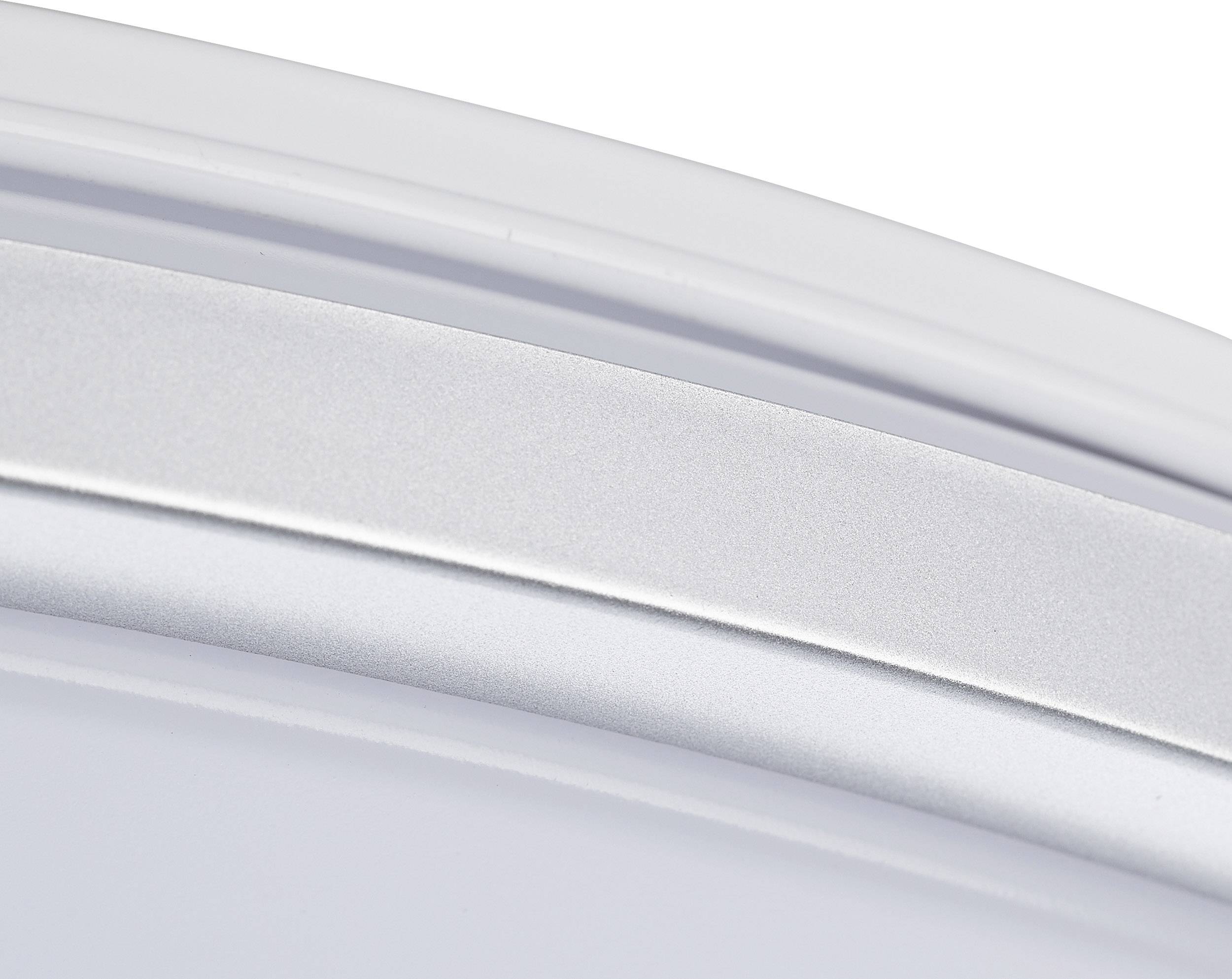 Detailný záber bielej a striebornej zakrivej plochy, pravdepodobne súčasti domáceho spotrebiča alebo lampy.