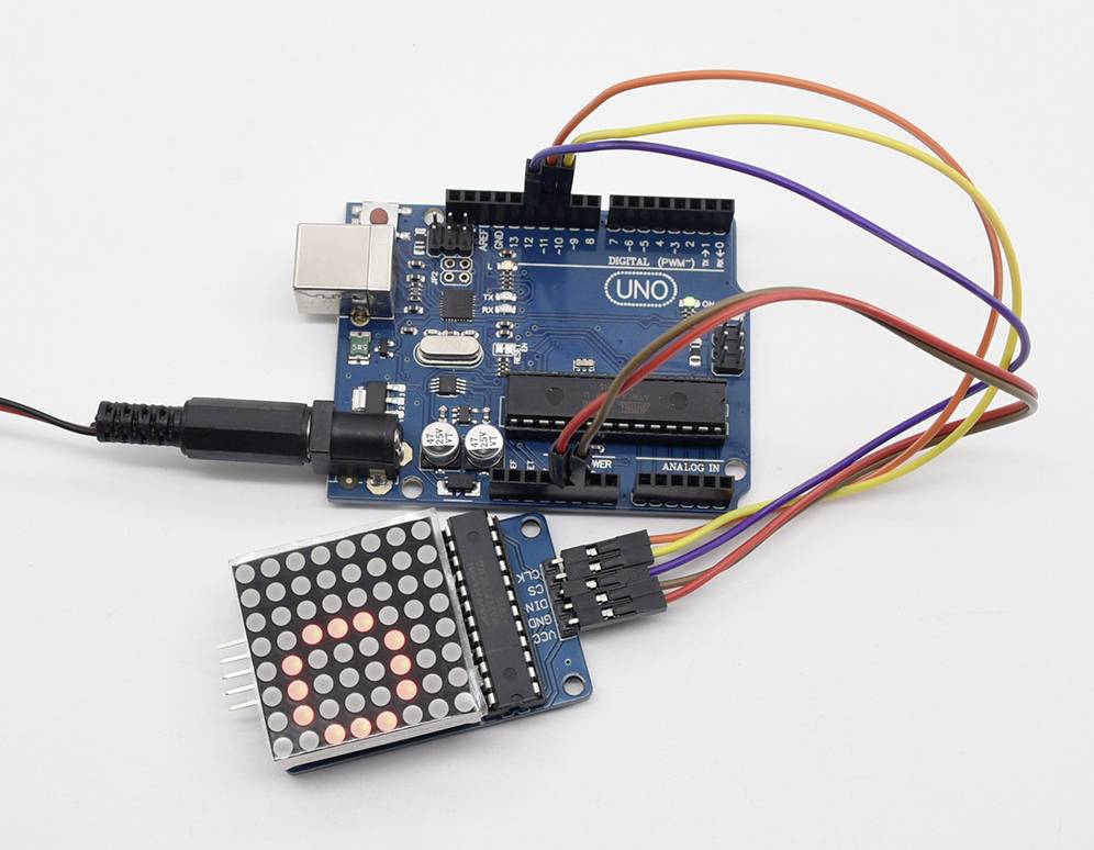 Doska Arduino je pripojená k LED displeju, ktorý zobrazuje číslo 9. Rôznofarebné káble zabezpečujú prepojenie.
