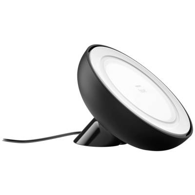 Čierna stolná lampa so skloneným, kruhovým tienidlom, stojaca na stole. Kábel vedie od lampy preč.
