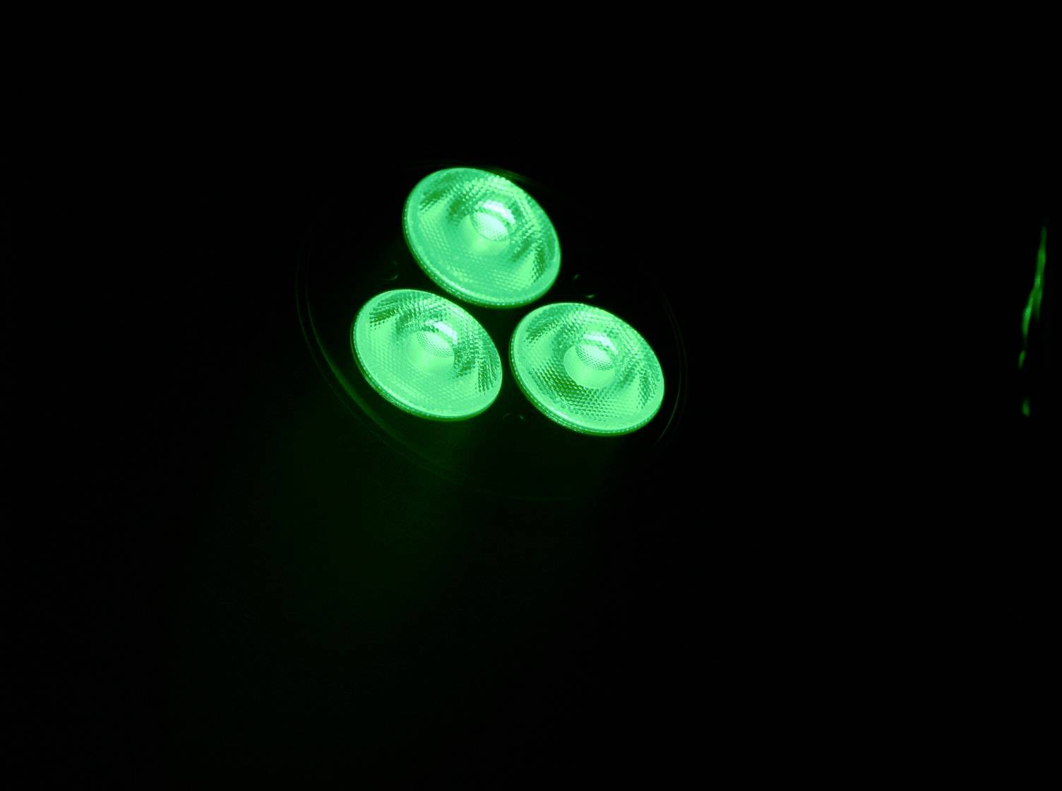 'Tri jasné, žiarivo zelené LED svetlá, ktoré svietia na čiernom pozadí.'