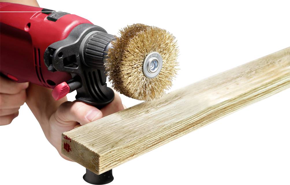 Osoba brúsi drevený doska elektrickým kefovým brúsnym strojom, aby vyhladila a vyčistila povrch.