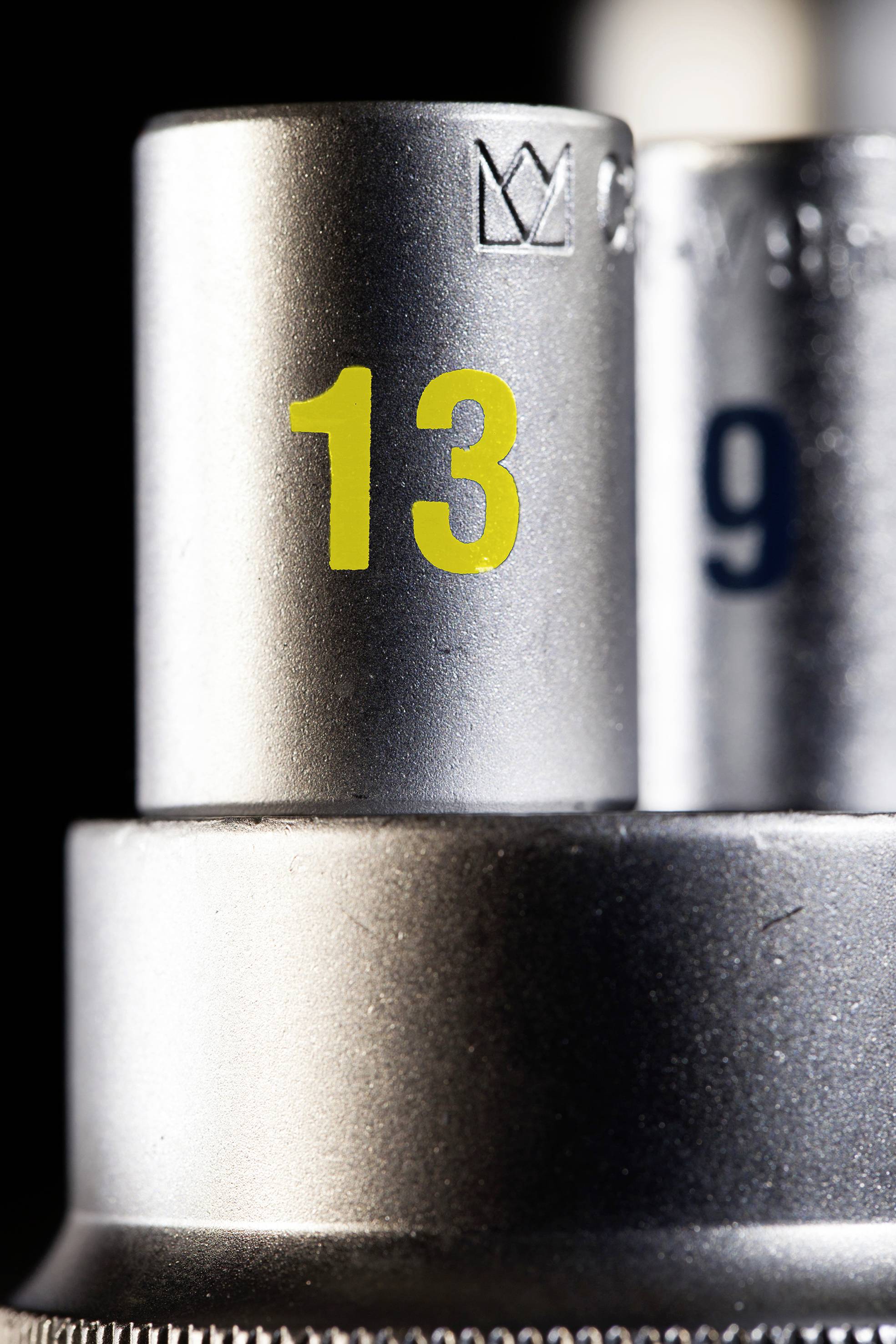 Dva strieborné kľúče, v popredí veľkosť '13' v žltom písme. Vzadu veľkosť '9'.