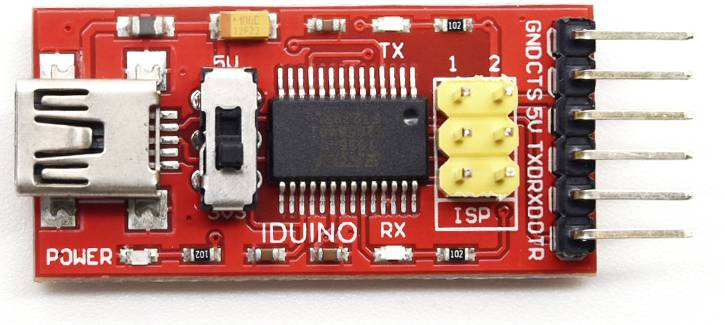Červený USB-sériový modul s čiernym čipom, dvoma žltými prepojkami a viacerými kontaktnými pinmi pre elektronické projekty.