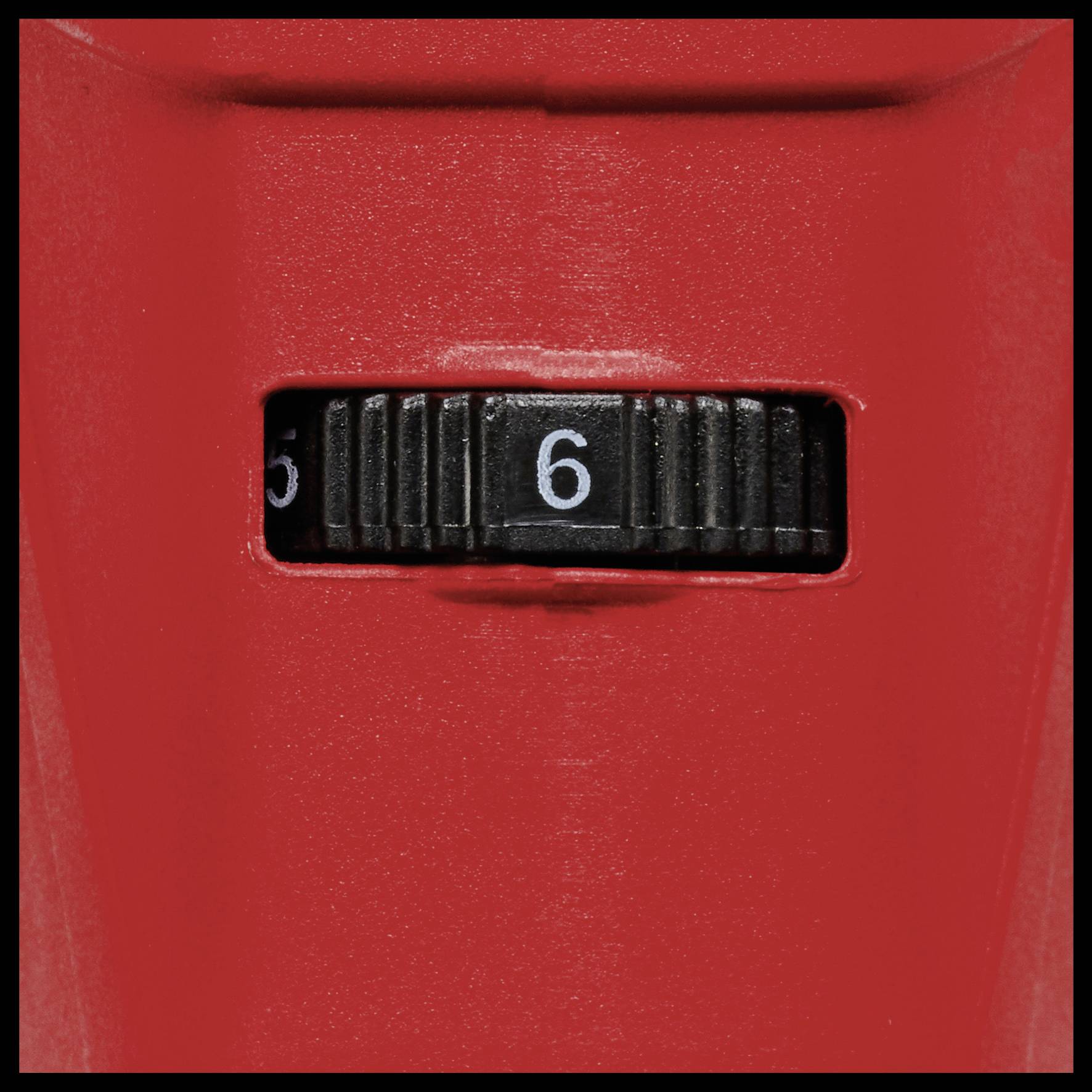 Červené zariadenie s čiernym nastavovacím kolieskom, ktoré smeruje na číslo 6.