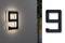 Osvetlené číslo domu '9' na stene jemne osvecuje okolie.