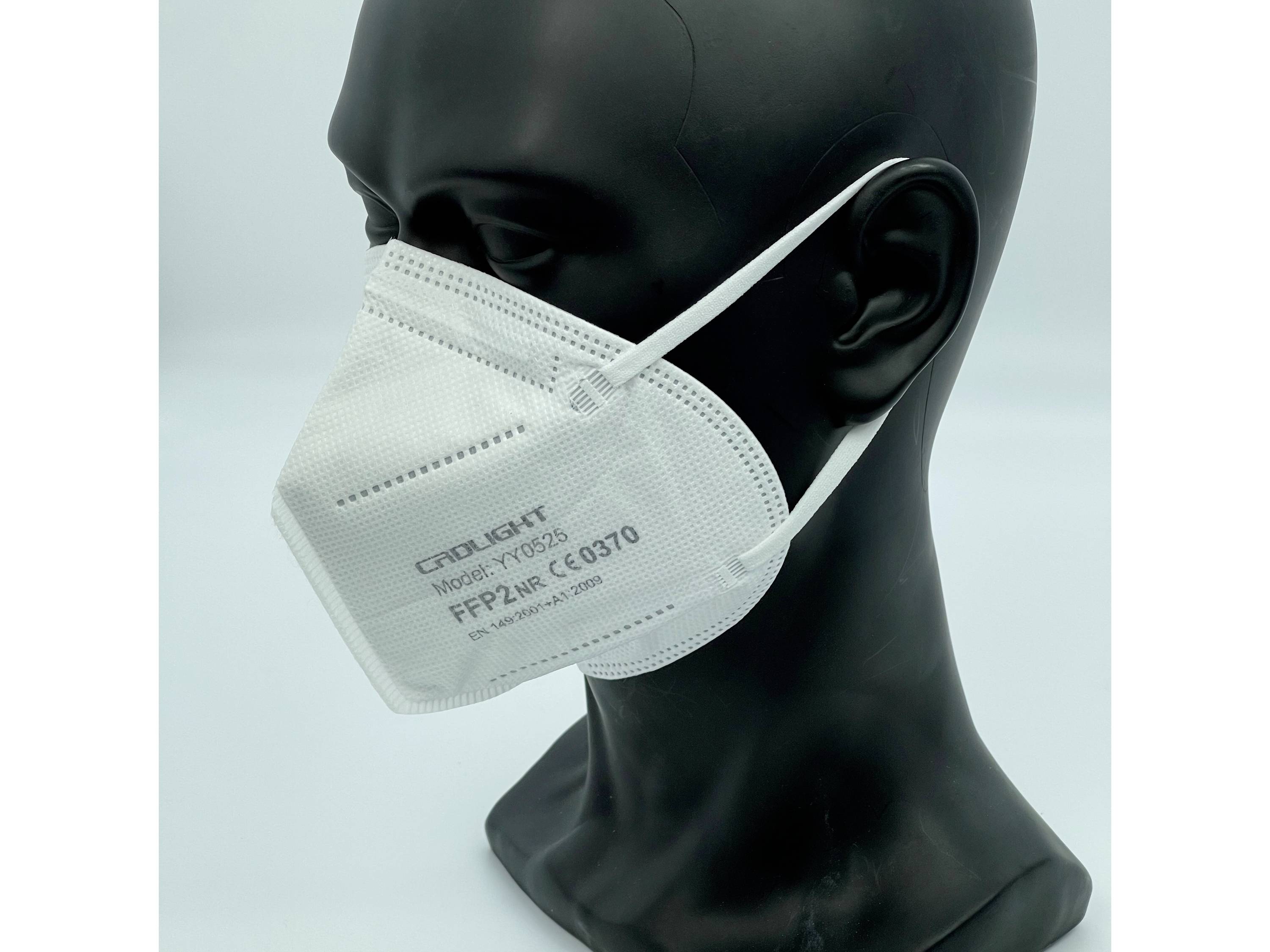 Čierna figurína v výklade má nasadenú bielu respiračnú masku FFP2 s nápisom 'Model YX033', certifikovanú CE 0370.