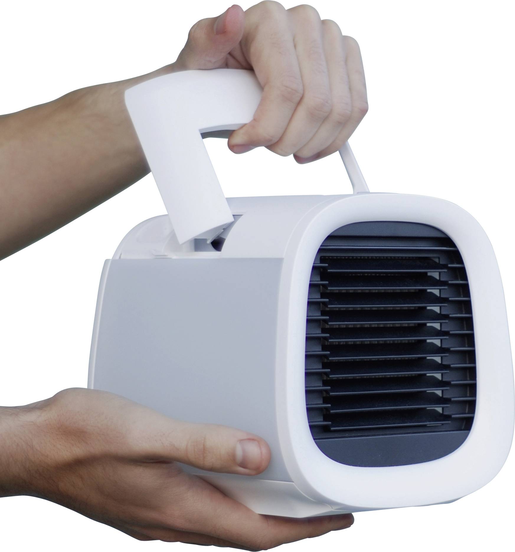 Osoba drží prenosný biely mobilný klimatizačný ventilátor s rukoväťou hore. Chladič je otočený dopredu a sú viditeľné vetracie štrbiny.