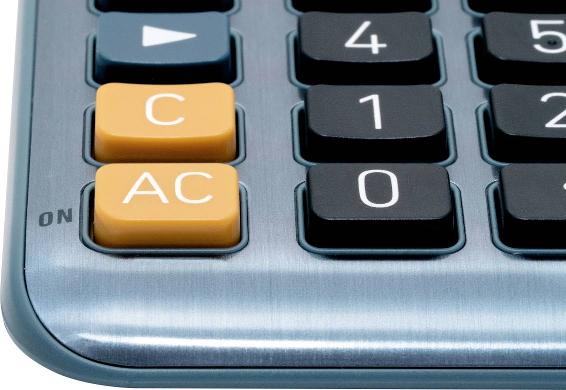 Detailný záber kalkulačky so zvýraznenými oranžovými tlačidlami 'C' a 'AC', obklopenými čiernymi numerickými tlačidlami.