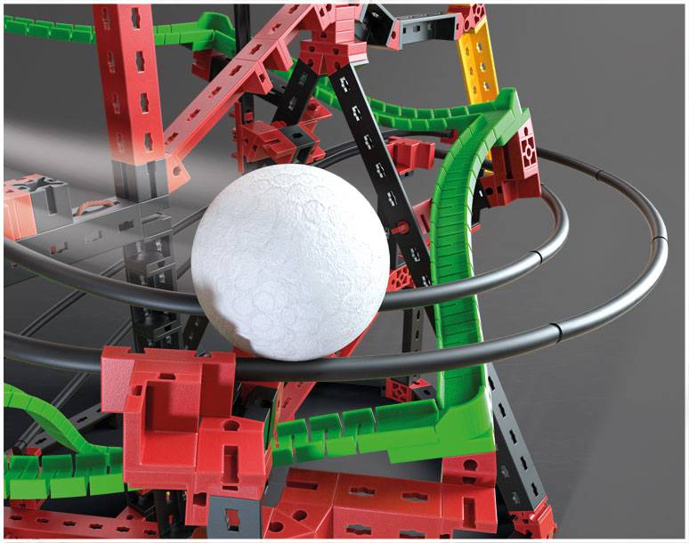 Biela guľa na dráhe zostavenej z červených, zelených a čiernych konštrukčných dielov.