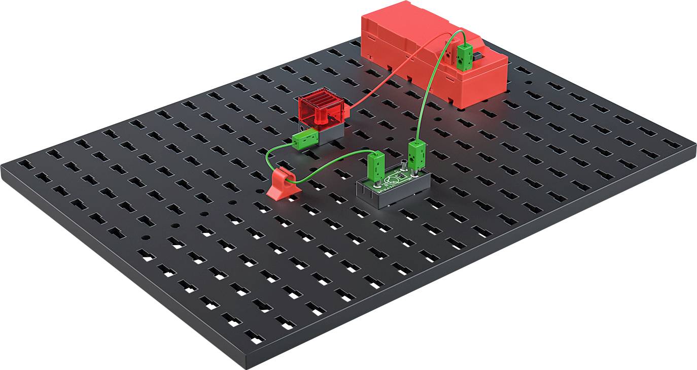 Čierna doska s červenými a zelenými elektronickými súčiastkami a vodičmi. Elektronický obvod na vysekávanej platforme.
