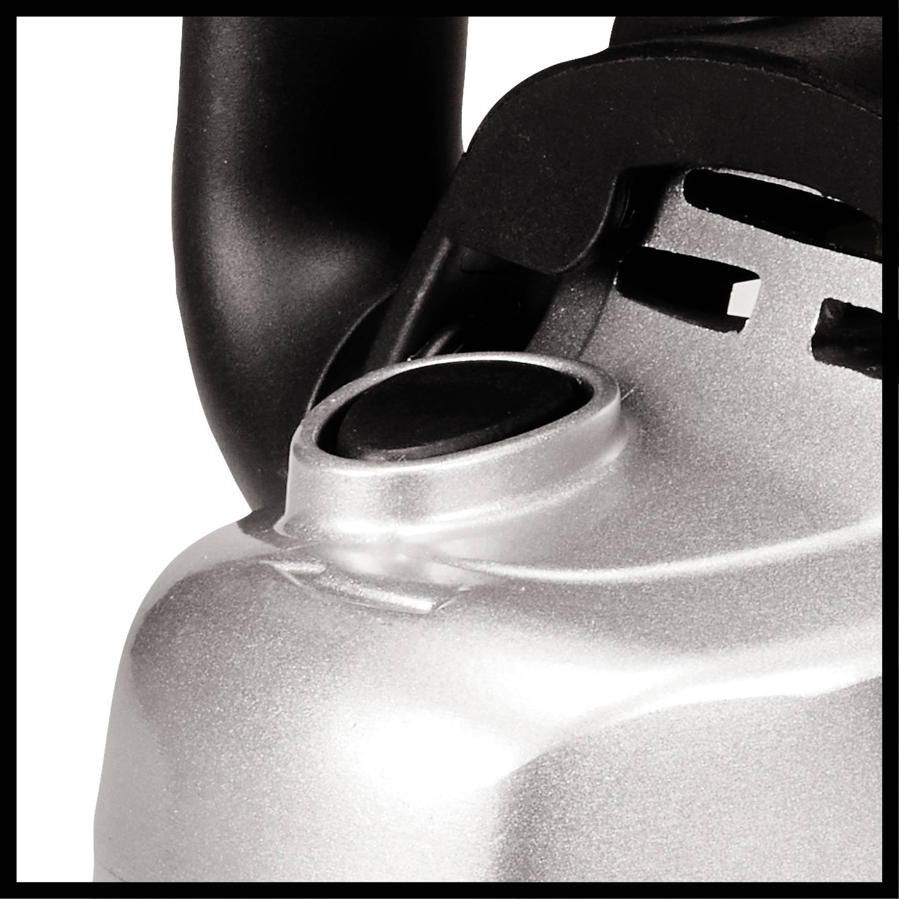 Detailný záber časti striebornej kanvice s zakrivskou rukoväťou.