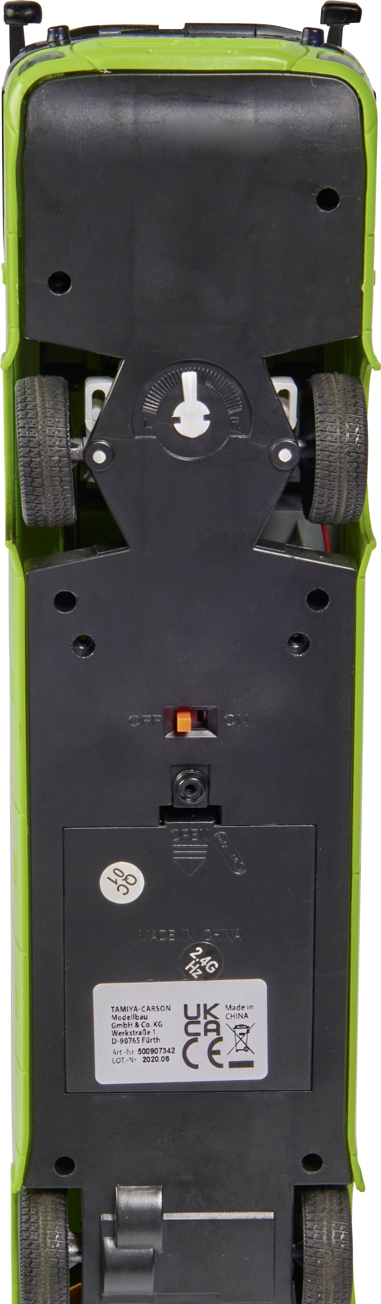 Spodný pohľad na hračkárske auto so čiernymi kolesami a zelenou karosériou, zobrazujúci priestor pre batérie a spínač zapnutia/vypnutia.