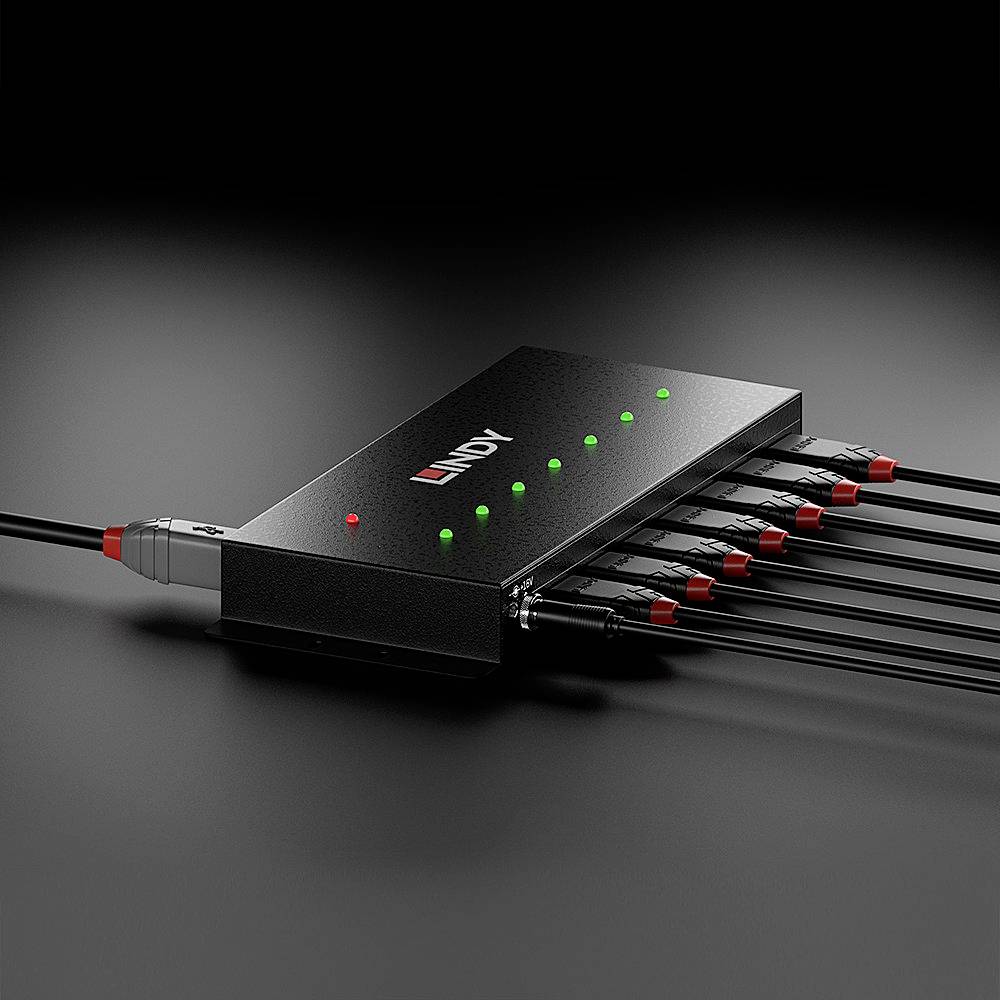 Čierne elektronické zariadenie s viacerými pripojenými káblami a zelenými svietiacimi LED diódami indikujúcimi prevádzkový stav.