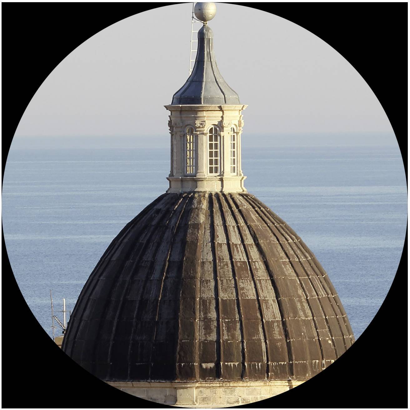 Kupola s malou vežou pred modrým horizontom mora.