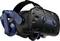 VR headset so svetlomodrou úchytkou a dvoma prednými kamerami. Názov značky 'VIVE' je zreteľne viditeľný na boku.