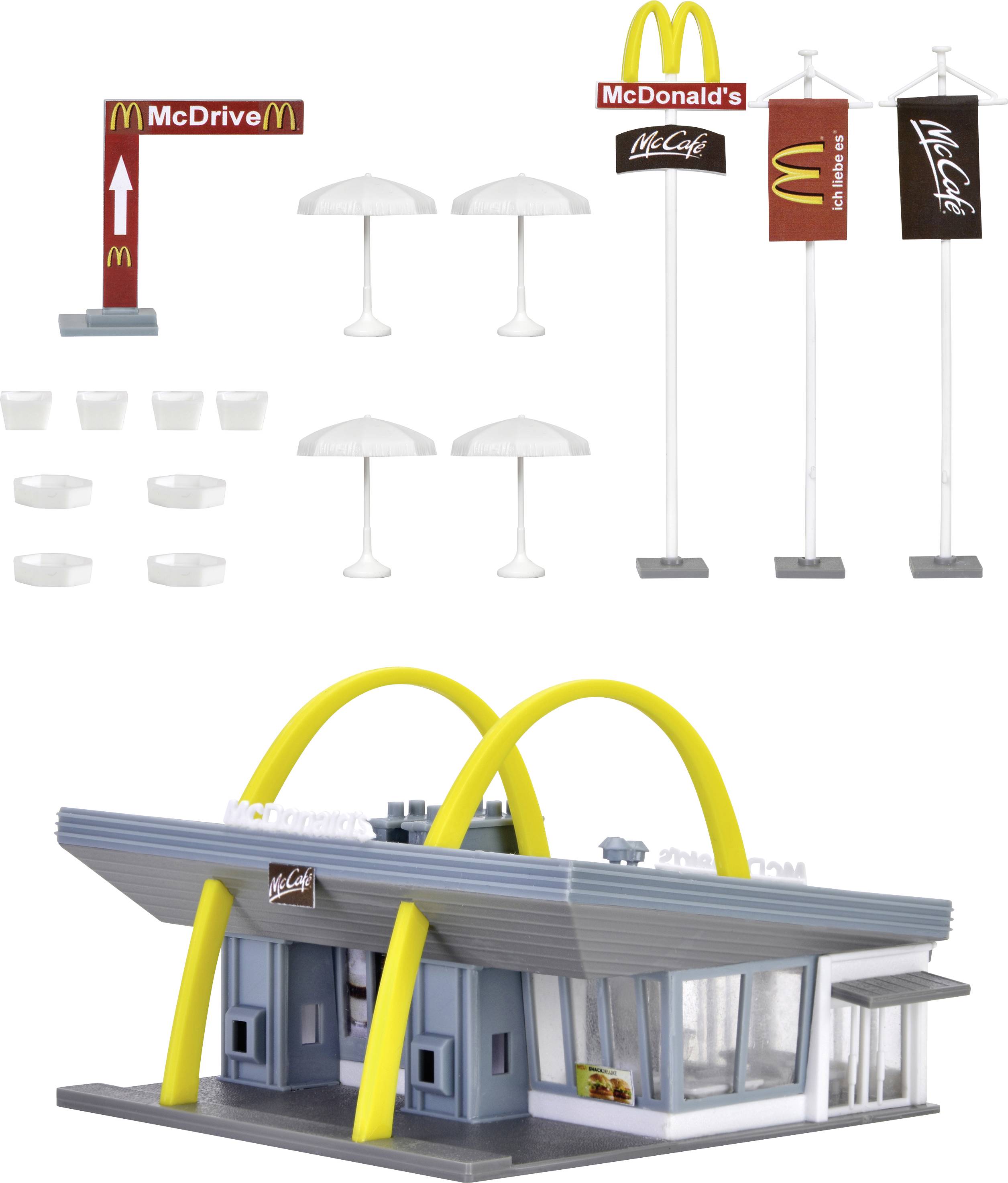Model rýchleho občerstvenia s žltými oblúkmi, logami McDonald's a McCafé, slnečníkmi, stožiarmi a stoličkami.