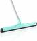 Tyrkysový stierač s dlhou rukoväťou na hladkom, lesklom povrchu. Nástroj na čistenie hladkých podláh.