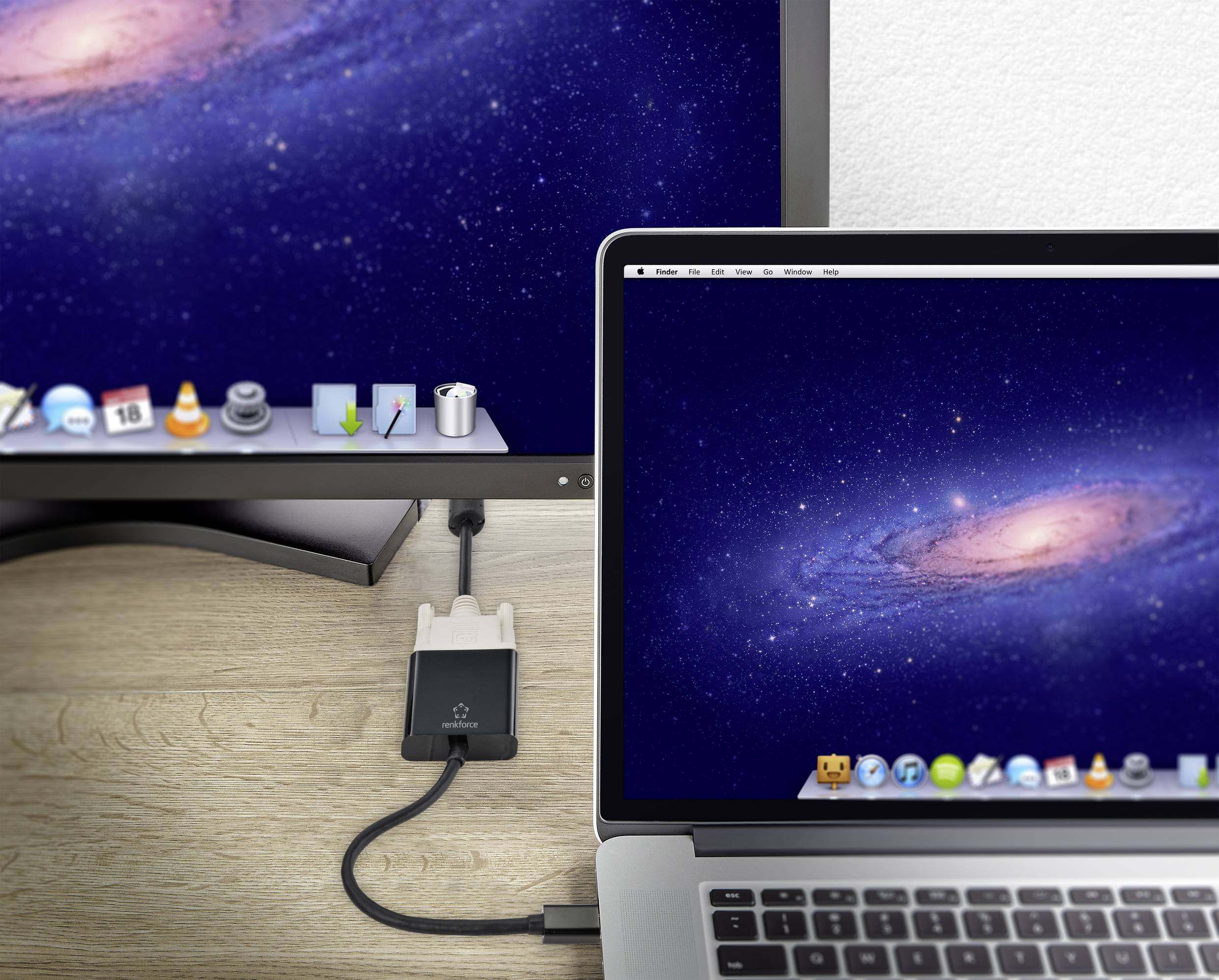 Laptop a monitor zobrazujú identické pozadie vesmíru. Laptop je pripojený k monitoru jediným káblom.