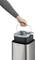 Ruka vyberá plný odpadkový kôš z kovového smetného koša.