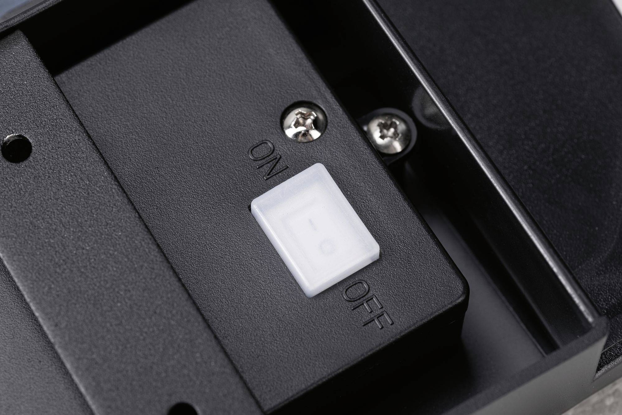 Čierny prepínač s polohami 'ZAP' a 'VYP', momentálne nastavený do polohy 'VYP', namontovaný na čiernom kryte.