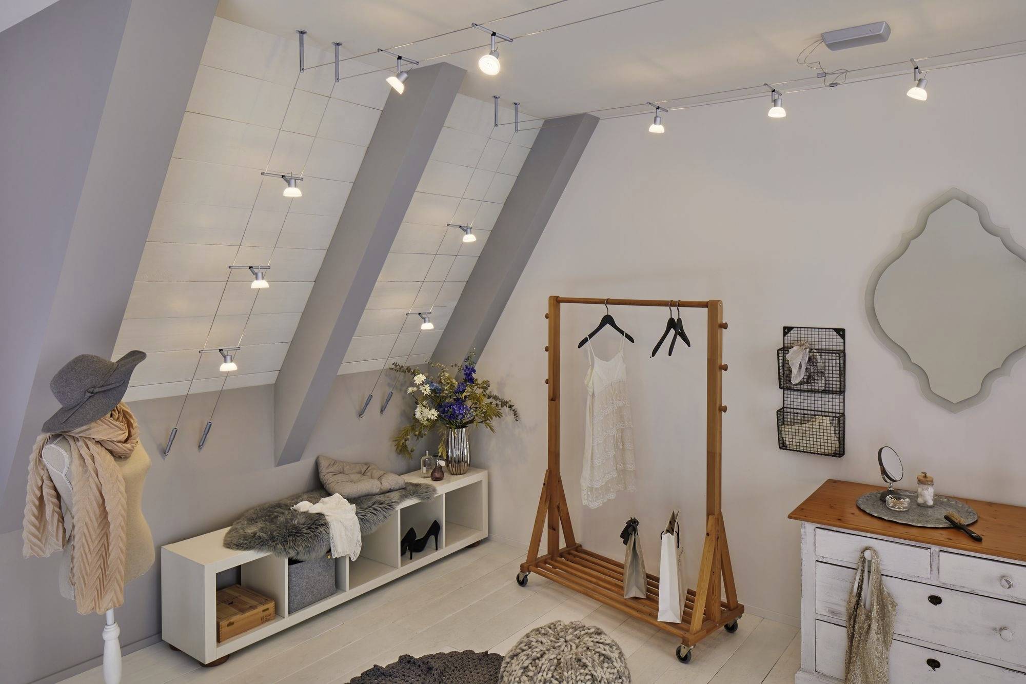 Štýlový módny butik s oblečením a doplnkami na vešiakoch a políciach. Moderné osvetlenie a dekorácie vytvárajú príjemnú atmosféru.