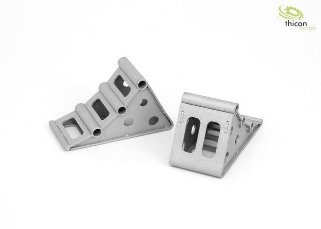 Dva strieborné trojuholníkové komponenty s obdĺžnikovými a kruhovými výrezmi. Slúžia ako štrukturálne spojovacie prvky.