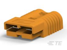 Krátky, oranžový prepojovací konektor s dvoma kovovými pinmi, používaný pre elektroinštalácie alebo elektronické zariadenia.