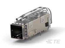 Kovová elektronická súčiastka obdĺžnikového tvaru s elektrickými prípojkami, pravdepodobne konektor alebo adaptér.