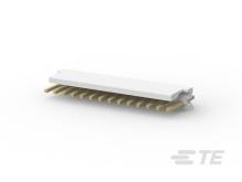 Biely elektronický konektor so zlatými kolíkmi ležiaci na svetlom povrchu.