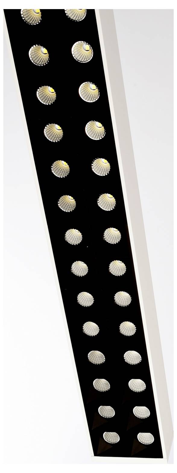 Detailný záber na moderný LED svetelný panel s radmi malých okrúhlych žiaroviek na čiernom páse, umiestnený pod uhlom na bielom pozadí.