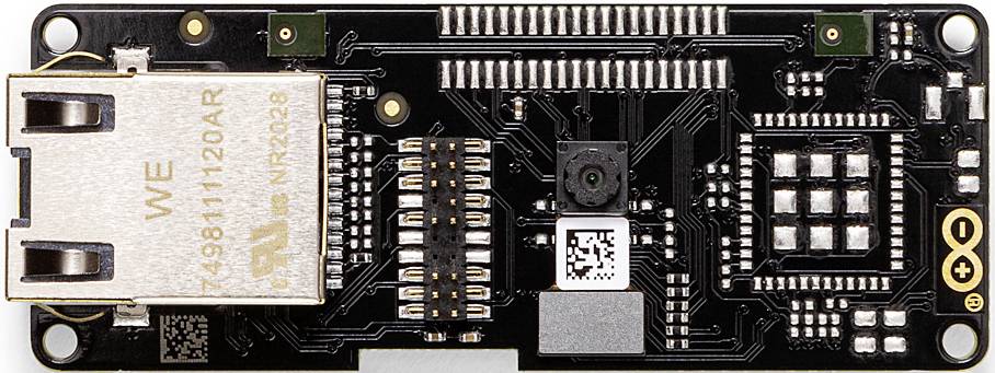Čierno-zlatá doska mikrokontrólera s ethernetovým pripojením a malým kamerovým modulom v strede, vhodná pre IoT projekty.