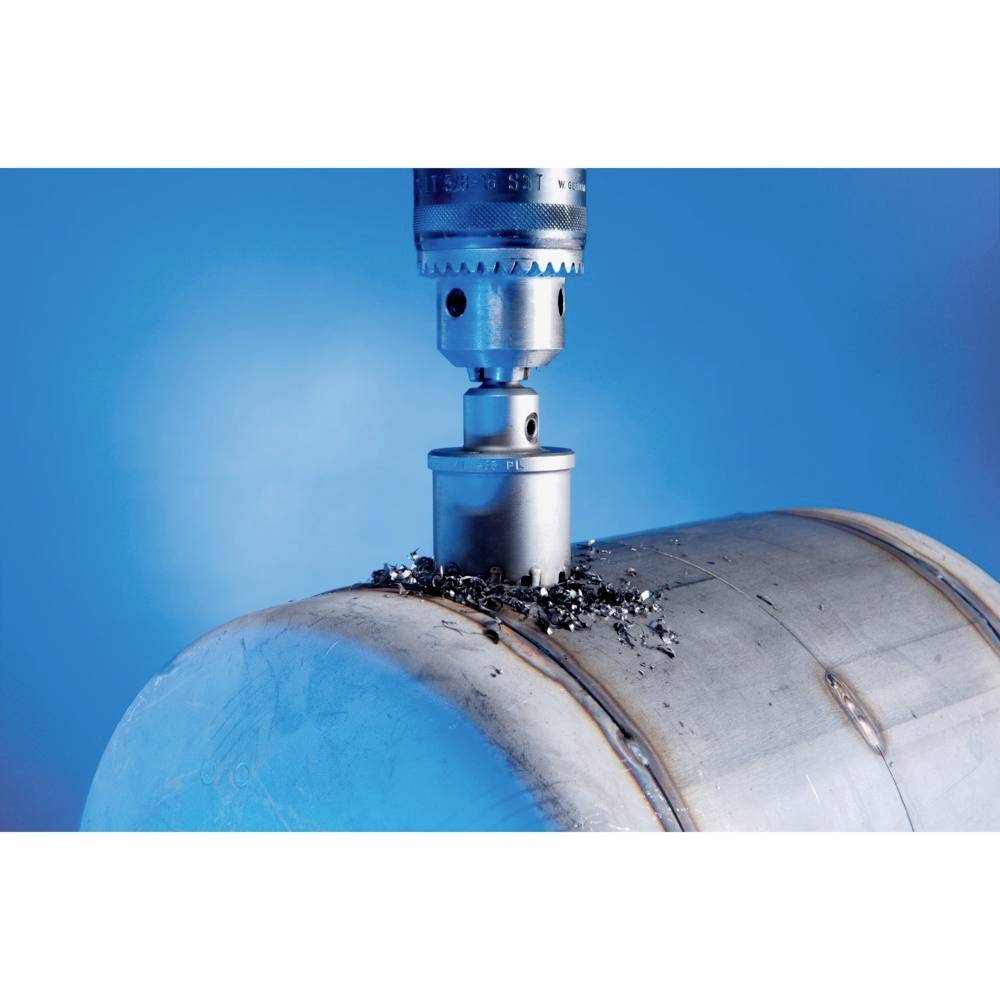 Kovový vrták vŕta do oceľovej platne, obklopený kovovými trieskami na modrom pozadí.