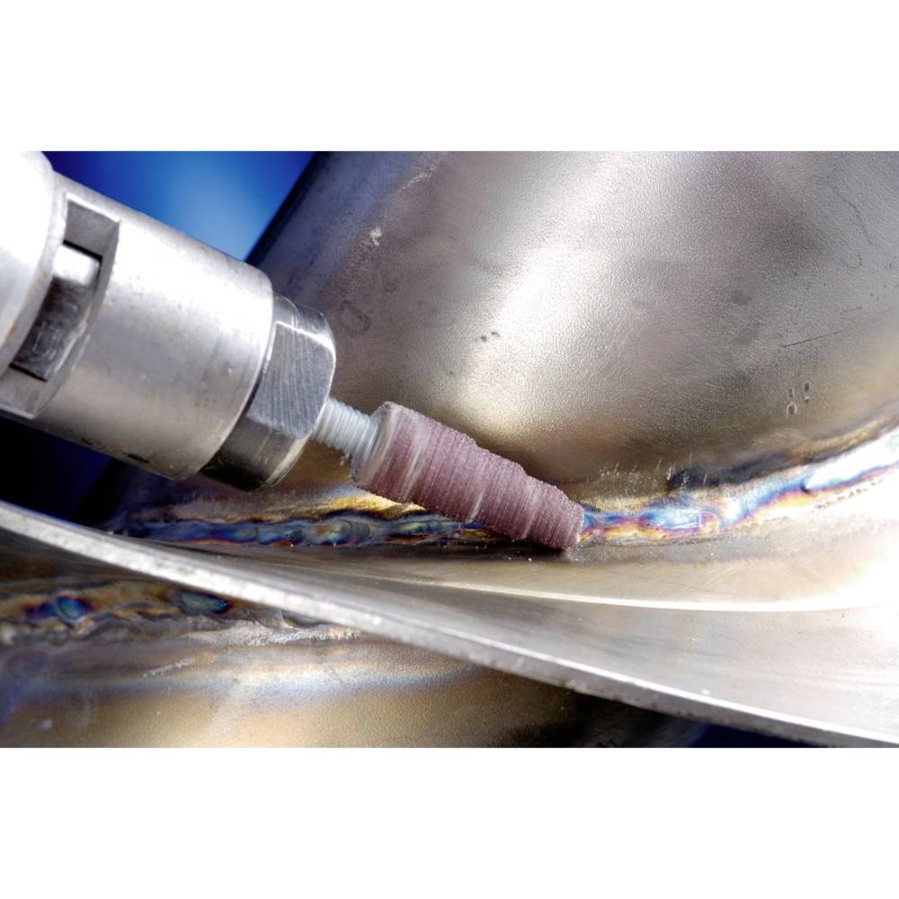 Detailný záber zvárania na kuse kovu. Rotujúci nástroj s brúsnym nadstavcom opracúva zvárací šev.