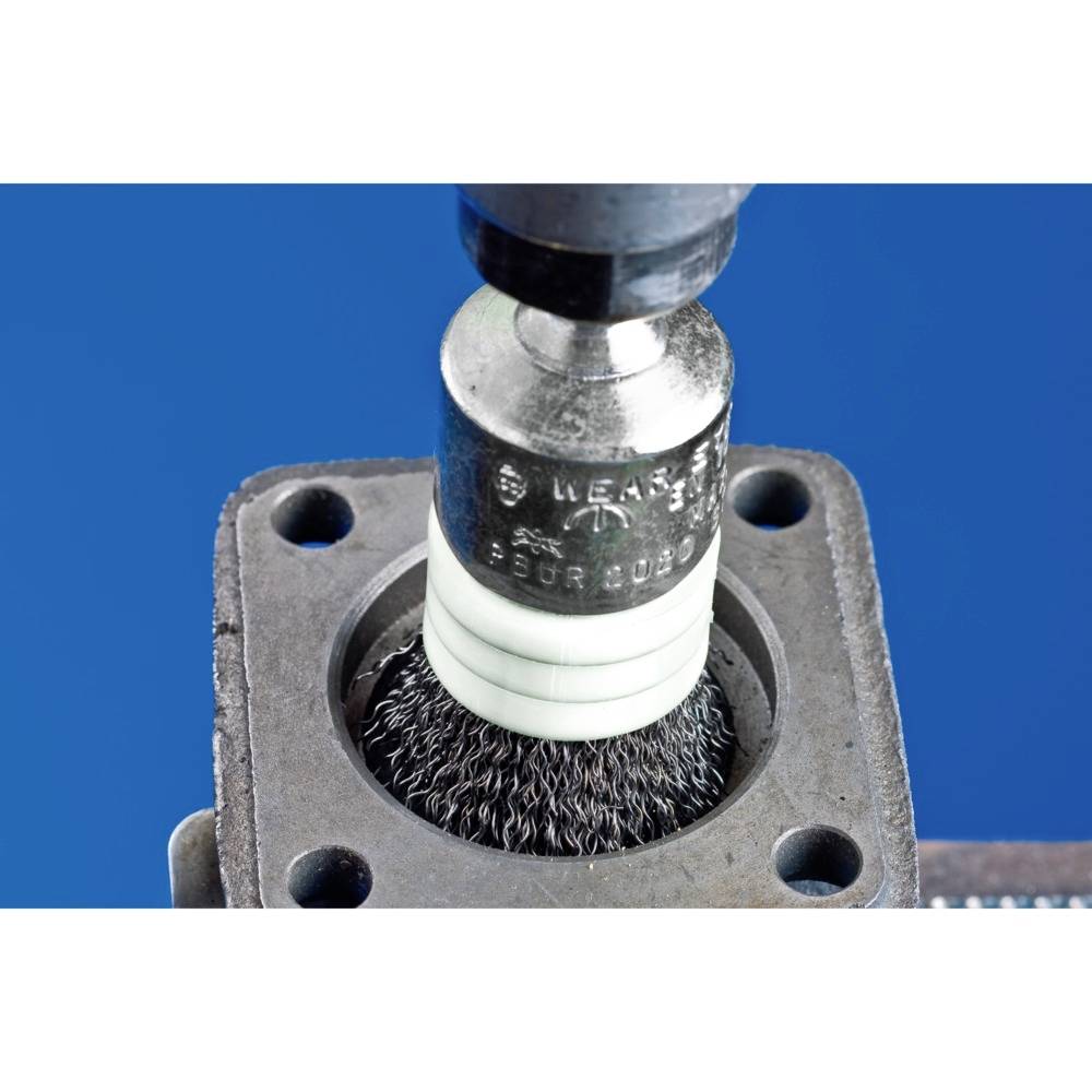 Kefovací stroj čistiaci kovový povrch; detailný záber ukazuje rotujúcu drôtenú kefu v akcii.