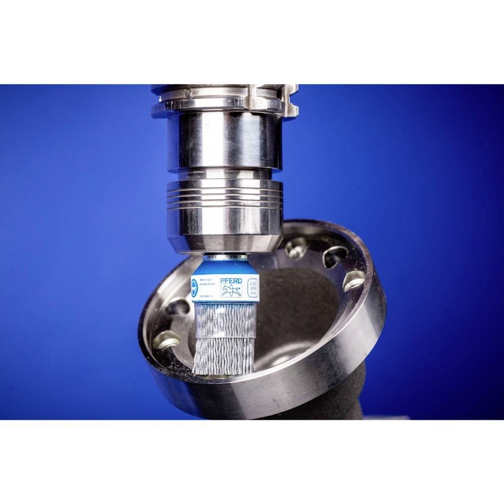 Kovový diel sa leští kefou. Kefa sa otáča rýchlo, aby vyhladila a vyčistila povrch kovu.