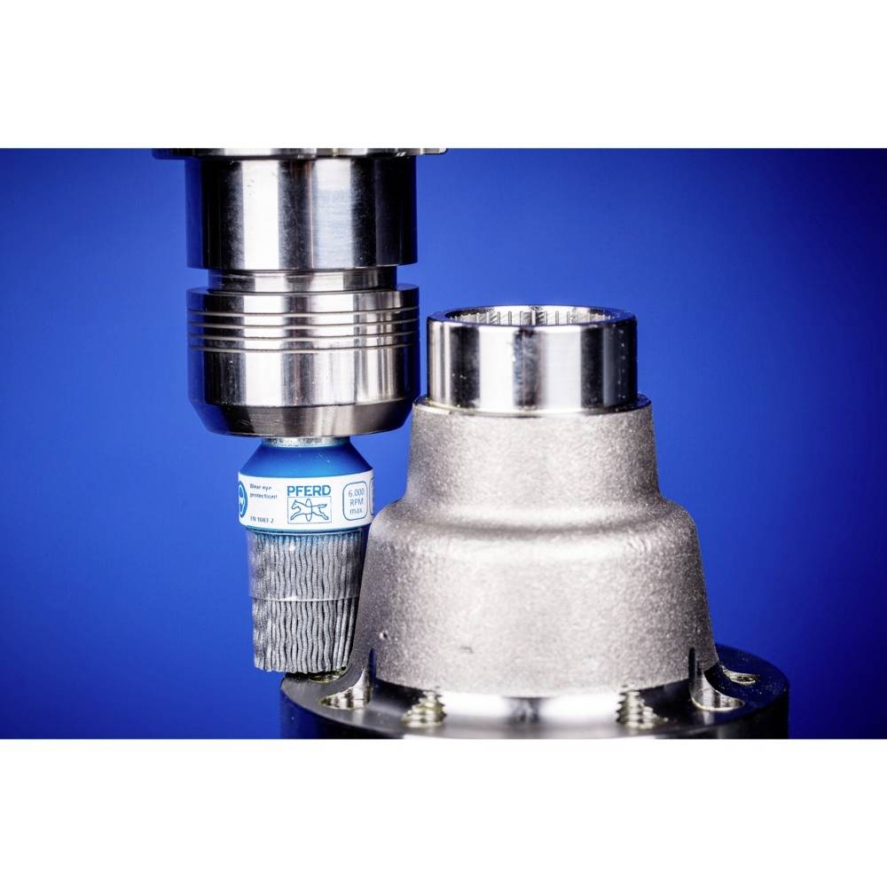 Viackomponentová hlava nástroja v detailnom zábere. Modrá súčiastka s potlačou vedľa strieborného valca, pred modrým pozadím.