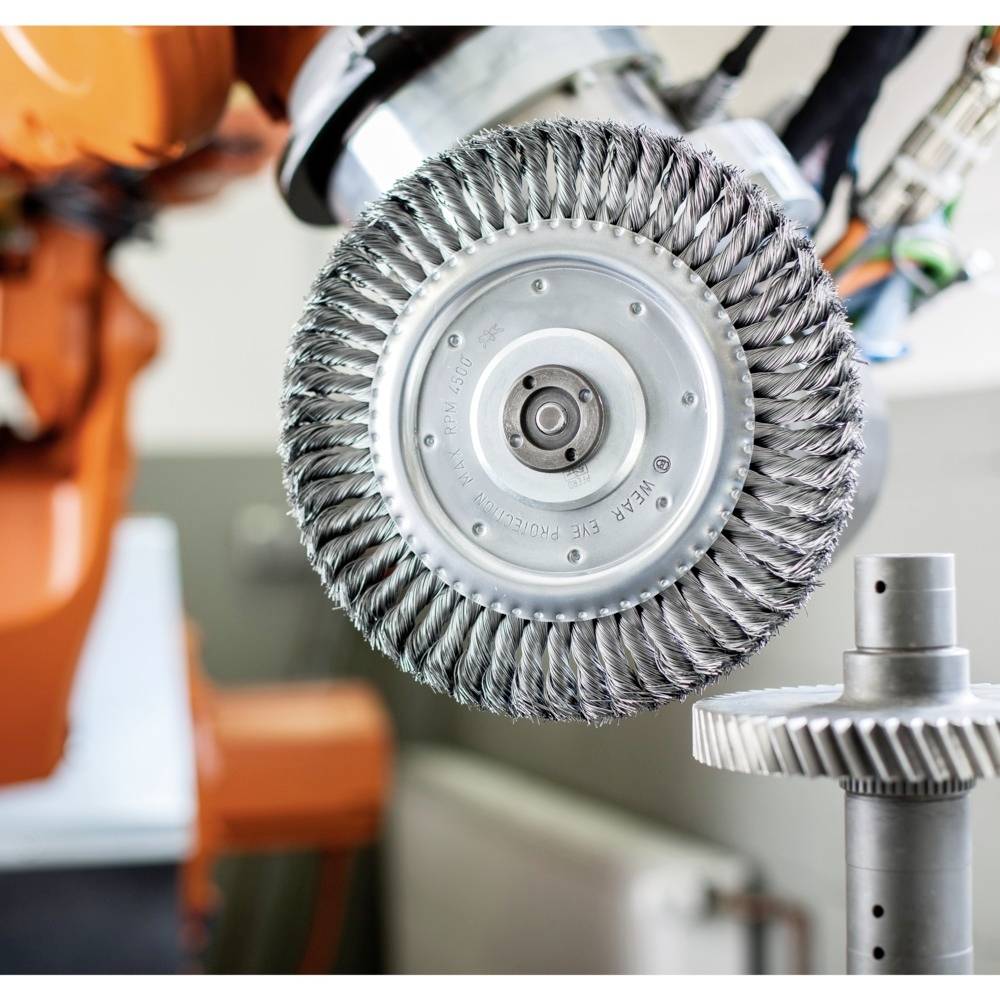 Priemyselný robot s brúsnym kotúčom obrába kovovité ozubené koleso. Zameraný na presné brúsenie v procese výroby.