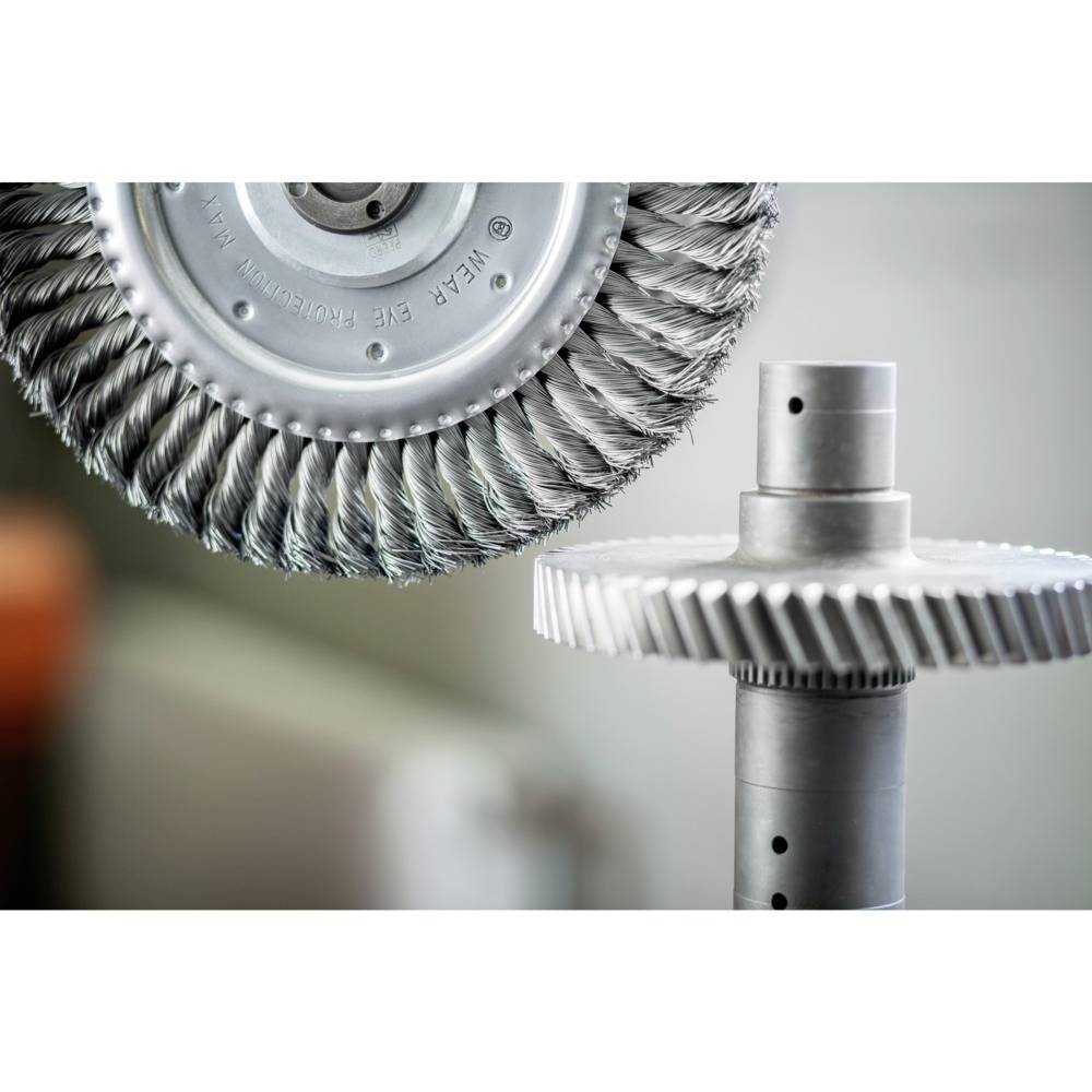 Dva strojové štetce; jeden v detailnom zábere s hustými štetinami, druhý namontovaný na hriadeli, rozmazané pozadie.